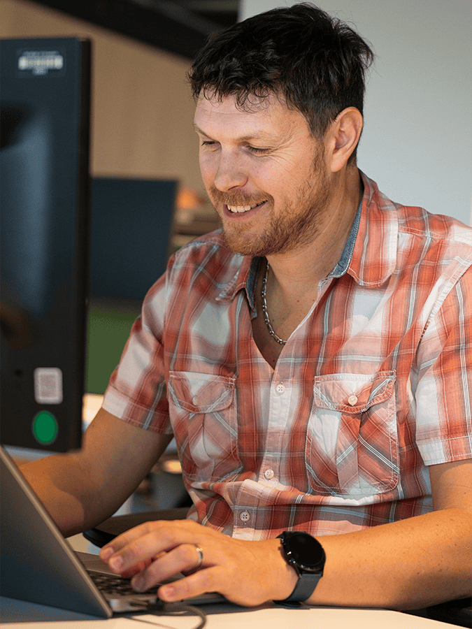 Collaborateur CPage souriant devant un ordinateur